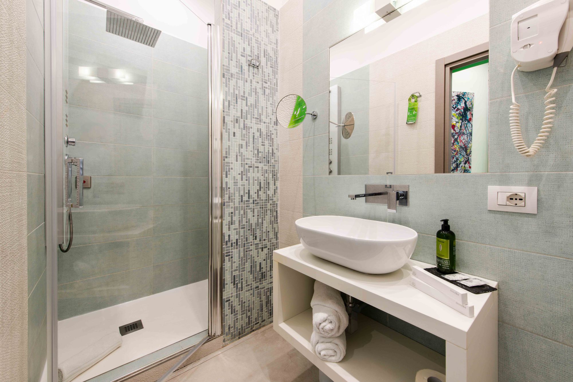 Bagno con doccia a soffione, mosaico a righe verde e grigio, lavabo ovale bianco e specchio ingranditore - Toledo16 Luxury Suites Napoli