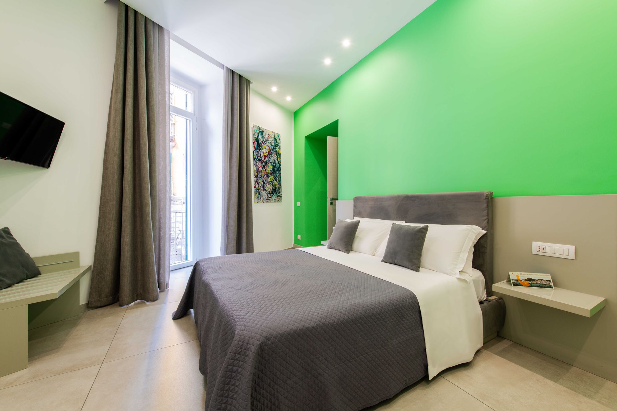 Camera doppia Deluxe con parete verde smeraldo e balcone su Via Toledo - Toledo16 Luxury Suites Napoli
