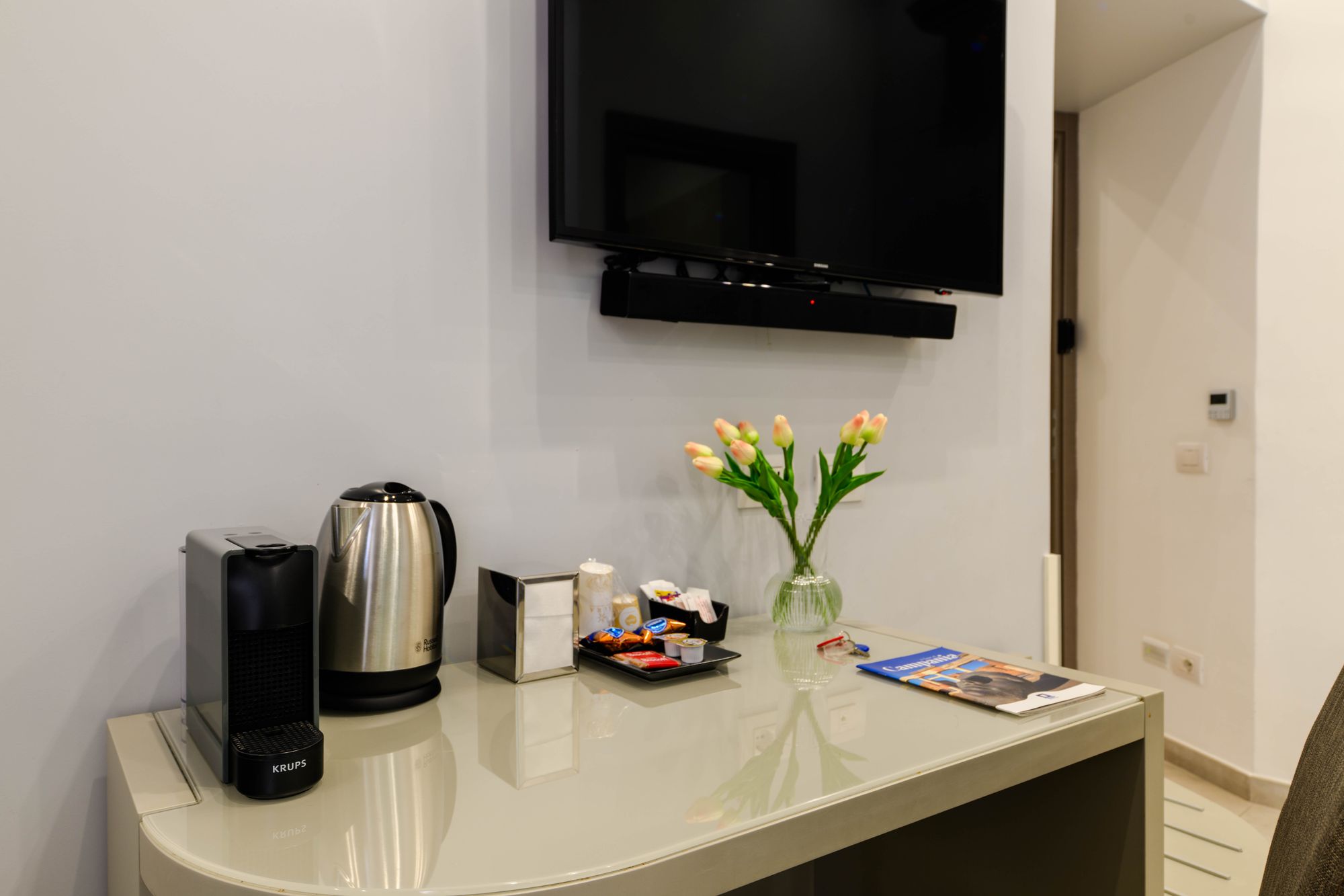 Scrivania con macchina da caffè Nespresso, bollitore, set di cortesia e vaso di tulipani - Toledo16 Luxury Suites Napoli