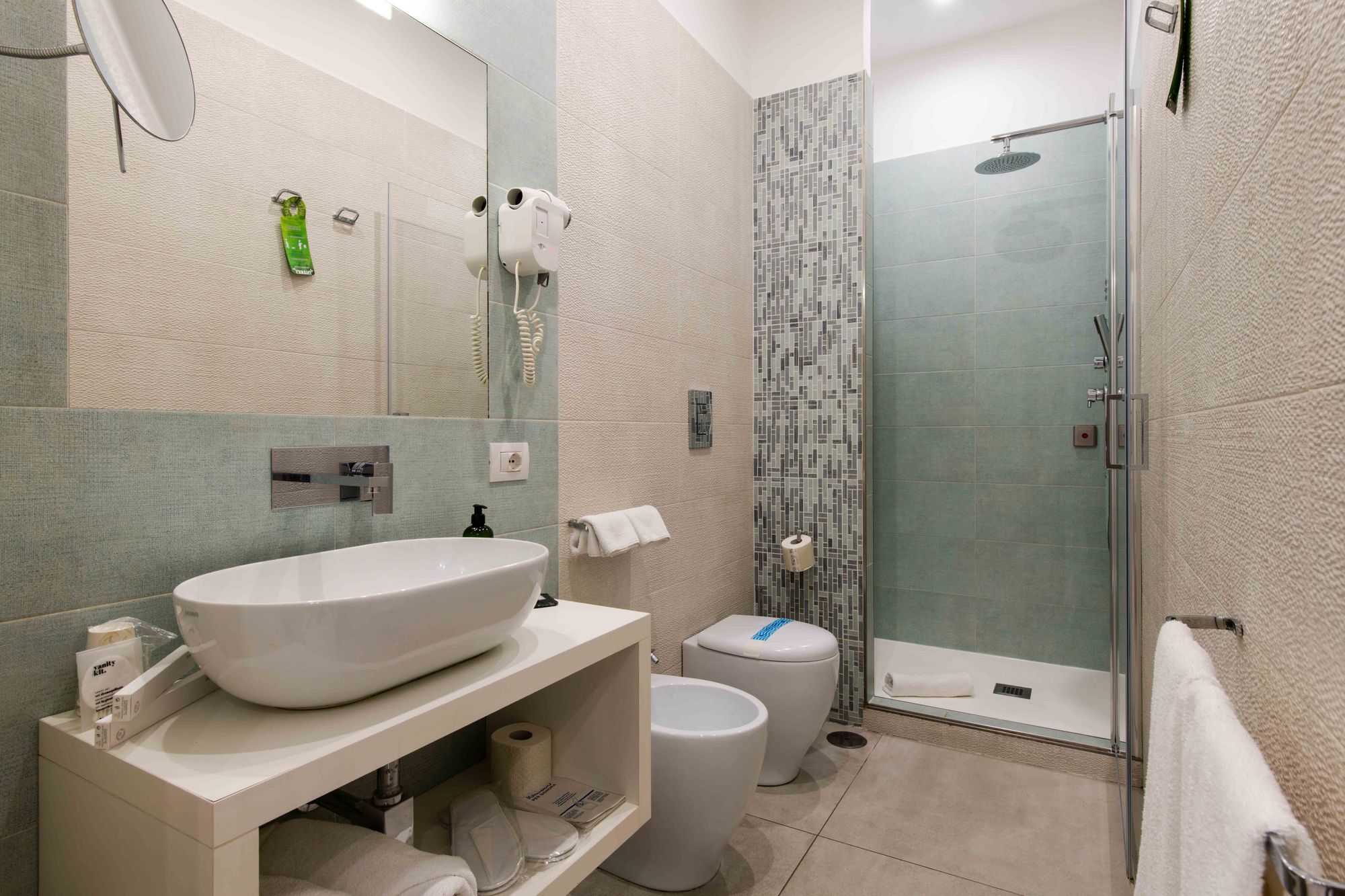 Bagno con lavabo d'appoggio, doccia con soffione a pioggia, piastrelle a mosaico e sanitari in ceramica bianca - Toledo16 Luxury Suites Napoli