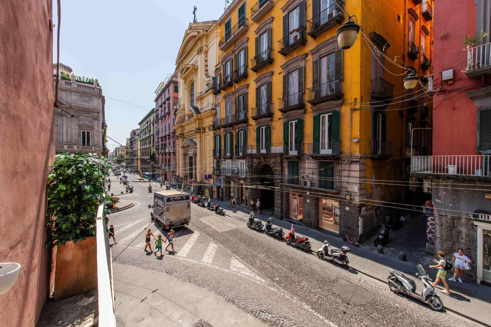 Vista panoramica dal balcone su Via Toledo, con i palazzi color giallo e rosa del centro storico di Napoli - Toledo16 Luxury Suites Napoli