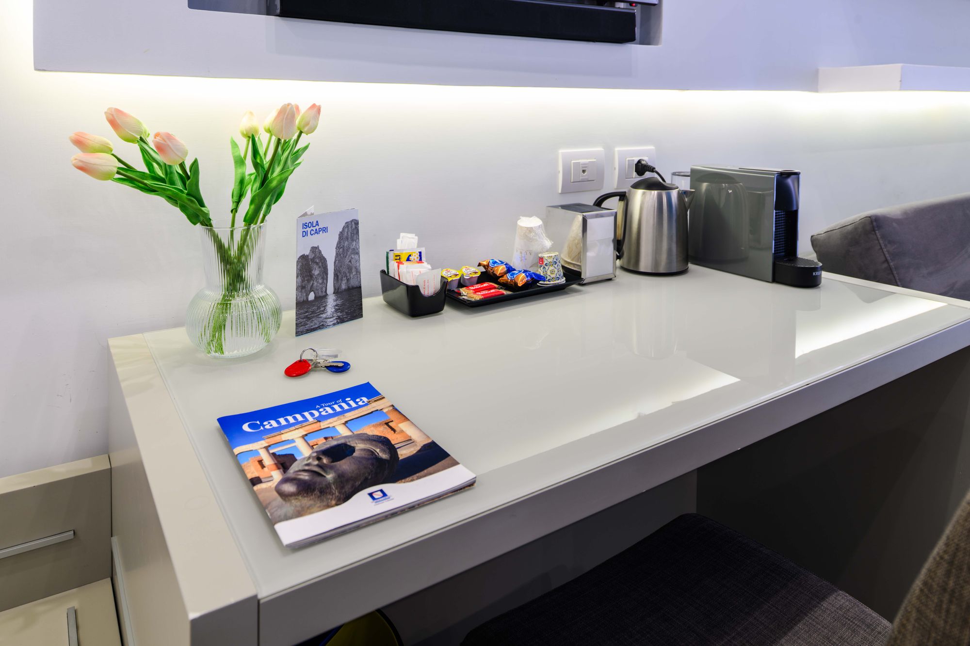 Scrivania con computer portatile, quotidiano internazionale, vaso di tulipani e vassoio di benvenuto - Toledo16 Luxury Suites Napoli