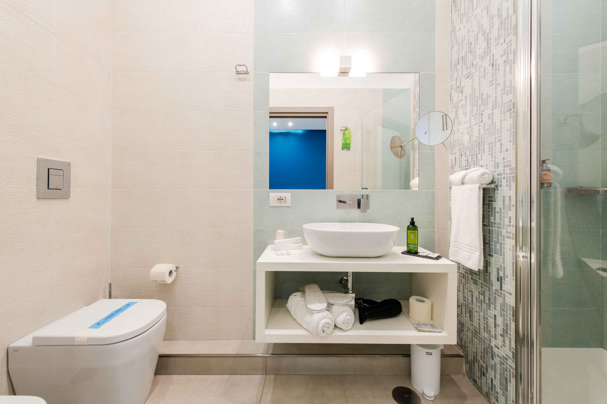 Bagno della suite con wc, bidet, lavabo d'appoggio bianco e doccia con piastrelle a mosaico - Toledo16 Luxury Suites Napoli