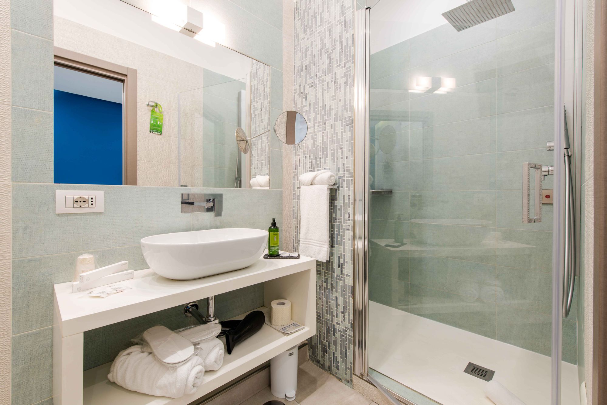 Bagno della suite con lavabo bianco, specchio con specchietto ingranditore, doccia con soffione a soffitto e asciugamani - Toledo16 Luxury Suites Napoli