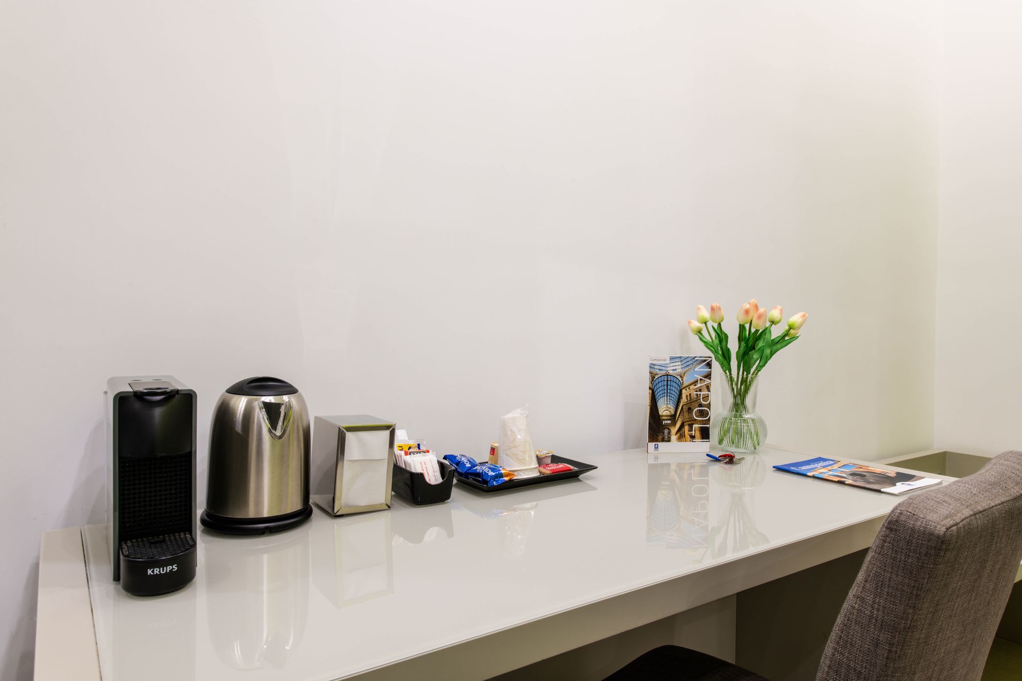Scrivania con macchina da caffè Krups, bollitore elettrico, porta tovaglioli e vaso di tulipani, camera B&B Napoli - Toledo16 Luxury Suites Napoli