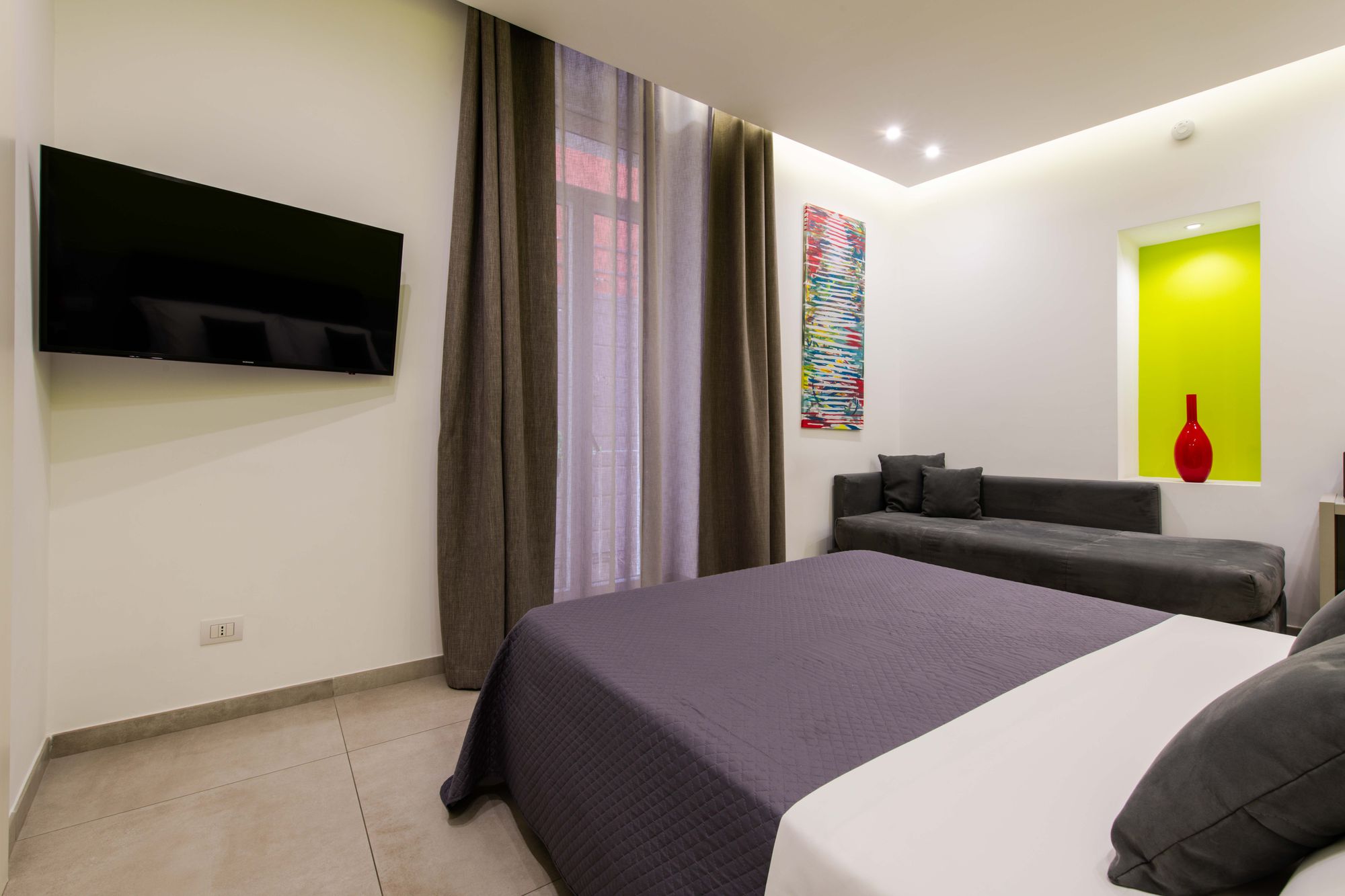 TV a schermo piatto montata a parete accanto a lunghe tende sulla porta finestra, camera B&B Napoli - Toledo16 Luxury Suites Napoli